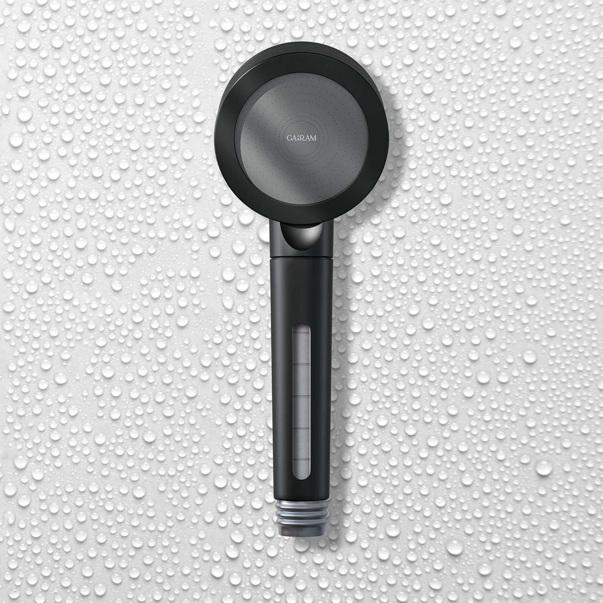 Front view of matte black filtered shower head against a water drop-covered wall